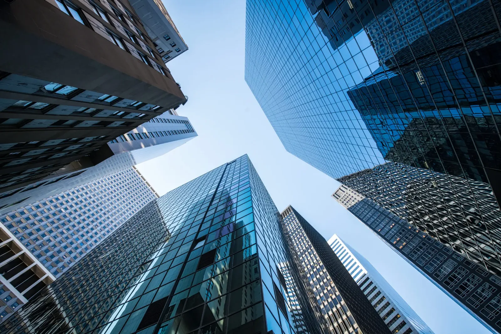 Upward view of modern corporate skyscrapers representing growth and success in private equity add-on acquisitions and sales integration strategies