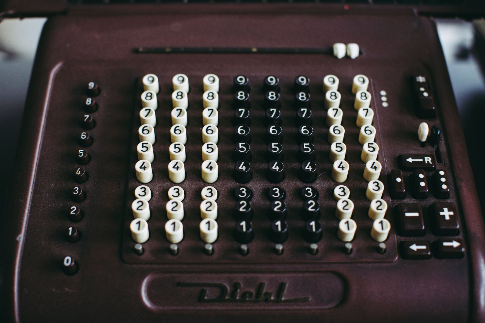 Close-up of a vintage Diehl mechanical calculating machine, its rows of numbered keys and arithmetic function buttons filling the frame, illustrating sales activity math that no longer produces the results it once did.